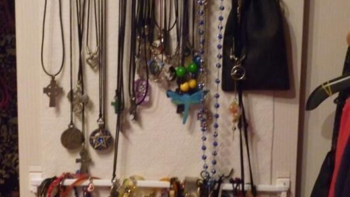 Ein Schmuckhalter zeigt viele Ketten und Armb&auml;nder, die ordentlich h&auml;ngen, um sie im Kleiderschrank zu organisieren.
