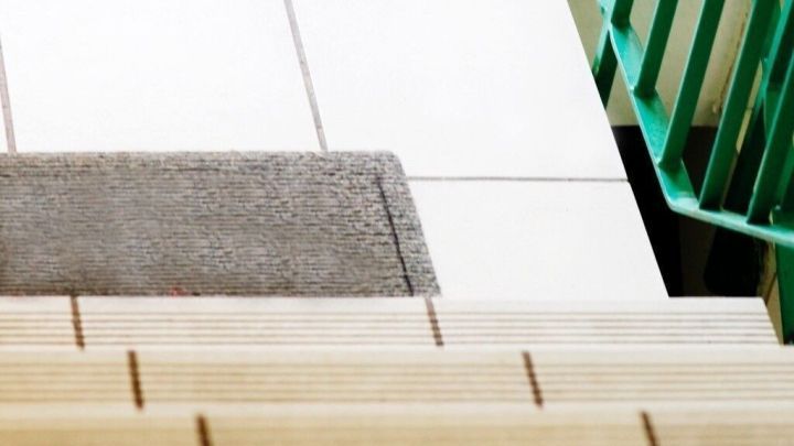 Auf den Treppenstufen liegt ein Teppich, um Schneematsch im Hausflur zu verhindern, w&auml;hrend die Treppe in einen modernen Flur f&uuml;hrt.