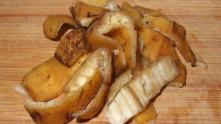 Eine Gruppe von Bananenschalen liegt auf einem Holzbrett, bereit zur Verwendung als preiswerte D&uuml;ngemittelquelle.