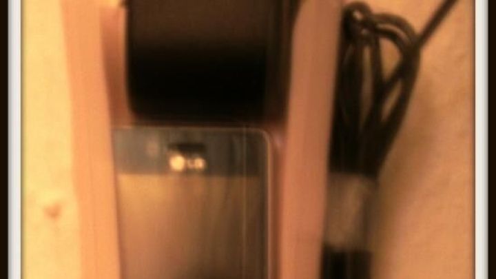 Eine selbstgemachte Handy-Ladestation steht auf einer Oberfl&auml;che, w&auml;hrend sie ein Kabel anschlie&szlig;t und aufgeladen wird.