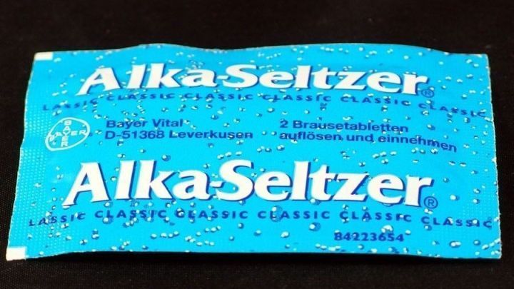 Ein blaues Alka-Seltzer-P&auml;ckchen liegt auf einem schwarzen Hintergrund, bereit zur Einnahme bei Blasenentz&uuml;ndung.