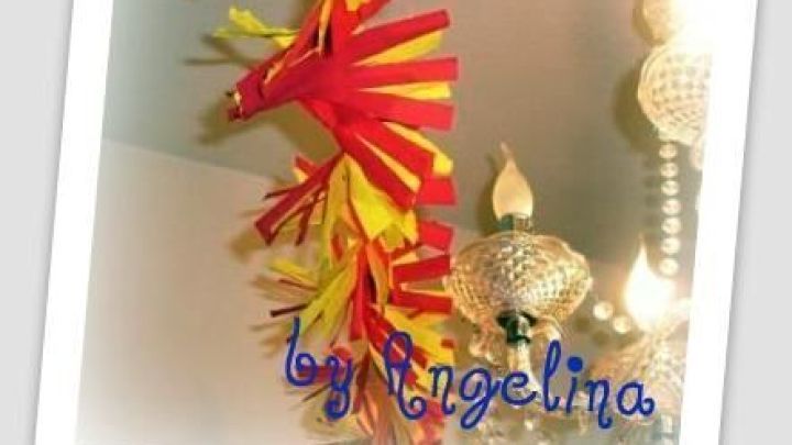 Bunte Girlande aus Krepppapier h&auml;ngt dekorativ von der Decke und bringt Farbe in den Raum unter einem Lichtlein.