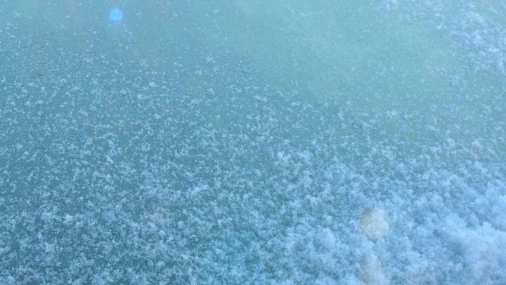 Eisfl&auml;chen bedecken das Auto, w&auml;hrend Wasser und K&auml;lte im Stau auf das Scheibenentfrosten warten.