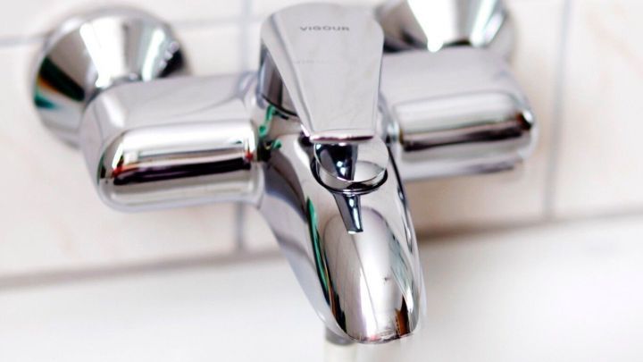 Ein gl&auml;nzender Wasserhahn im Bad sprudelt, w&auml;hrend der Raum f&uuml;r den Besuch der Schwiegermutter vorbereitet wird.