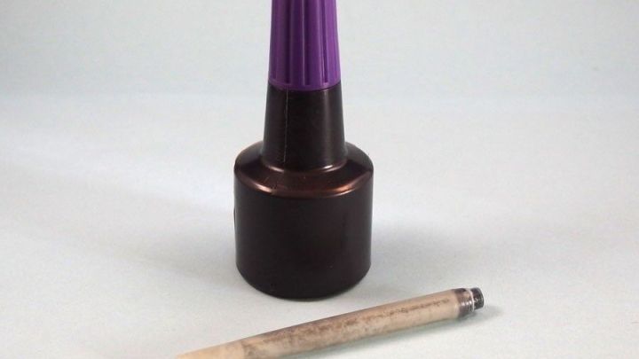 Ein Tintenfl&auml;schchen mit lila Deckel steht neben einer leeren Patrone, bereit zum Nachf&uuml;llen f&uuml;r den Tintenverbrauch.