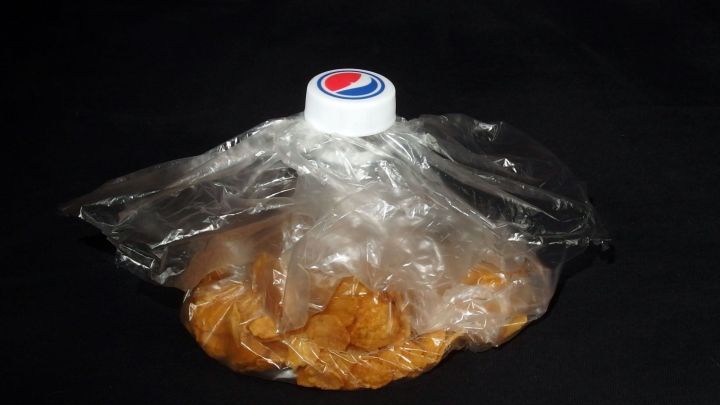 Eine Plastikflasche wird verwendet, um eine Plastikt&uuml;te, die Kekse enth&auml;lt, fest zu verschlie&szlig;en und frisch zu halten.