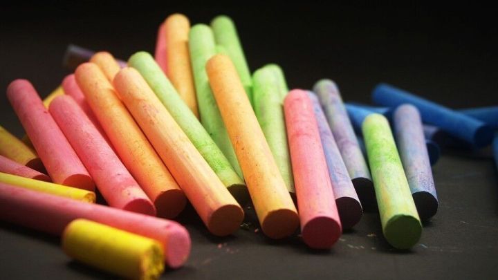Bunte Kreide liegt verstreut auf einem dunklen Untergrund, bereit, um feuchte Schr&auml;nke zu trocknen.
