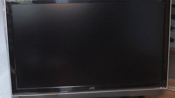 Ein ausgeschalteter Fernseher steht auf einem Tisch, umgeben von einem hellen Raum, was einen fernsehfreien Tag symbolisiert.