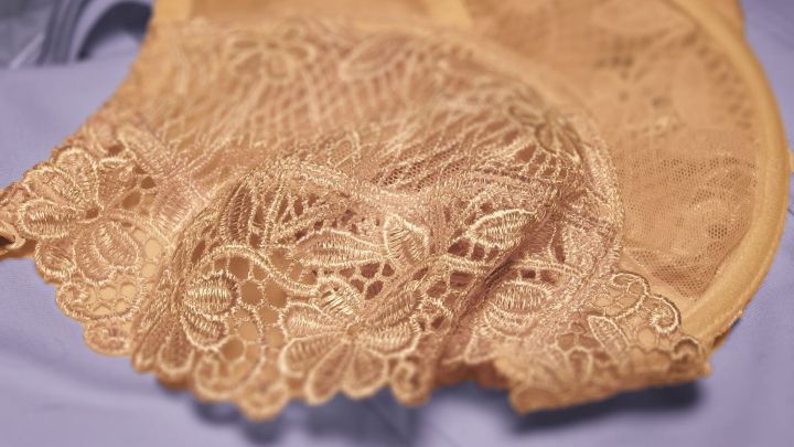 Vergilbte Unterw&auml;sche liegt auf einem blauen Hintergrund, dekorativ mit feiner Spitze, bereit zum F&auml;rben.