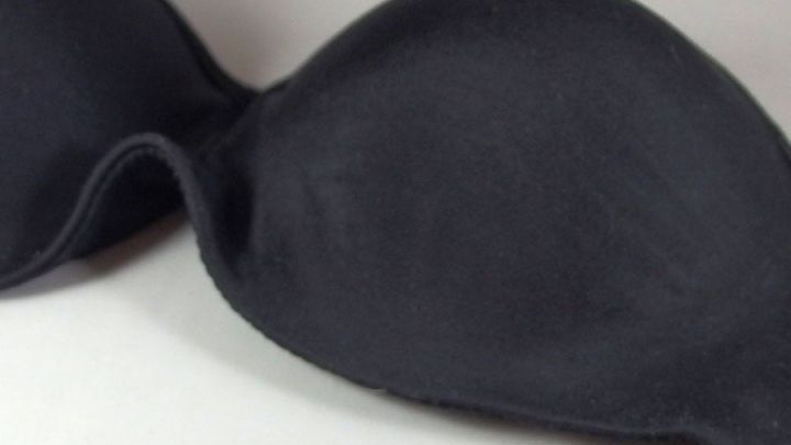 Ein schwarzer BH liegt auf einer wei&szlig;en Unterlage, die eine Reparatur ben&ouml;tigt, um das Quietschen zu stoppen.