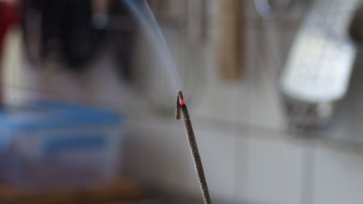 R&auml;ucherst&auml;bchen rauchen und verbreiten aromatischen Rauch in einer hellen, modernen K&uuml;chenszene.