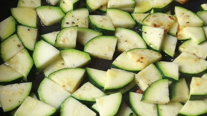 Zucchini-St&uuml;cke werden in einer Pfanne bei mittlerer Hitze angebraten, um einen sommerlichen Geschmack zu entfalten.