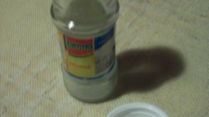 Ein leerer Einweg-Gew&uuml;rzstreuer steht auf einem Tisch; der Plastikdeckel liegt daneben. Auf dem Etikett steht "Meersalz".