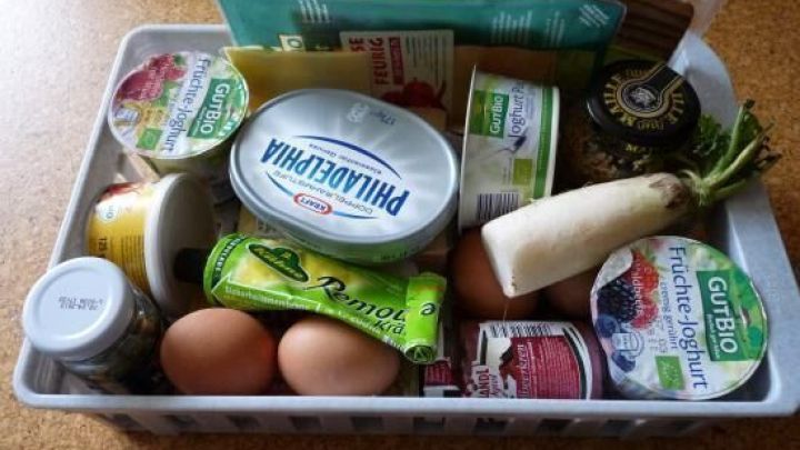 In einem Korb liegen verschiedene angebrochene Lebensmittelpackungen, darunter Joghurt, Eier und ein gro&szlig;er Becher Frischk&auml;se.