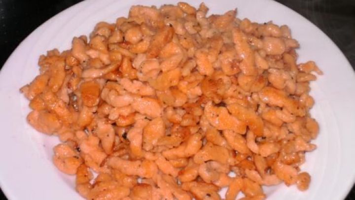 Auf einem wei&szlig;en Teller liegen dampfende Tomaten-Basilikum-Sp&auml;tzle, die appetitlich frisch zubereitet wirken.