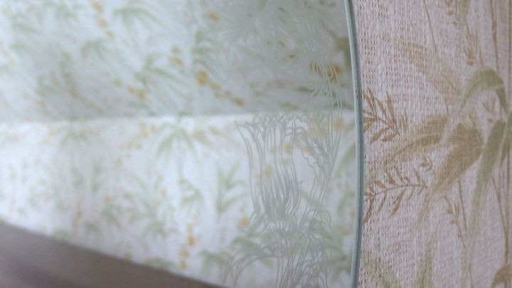 Ein Glastisch steht auf einem blumigen Hintergrund und reflektiert die Umgebung, wirkt sauber und streifenfrei.