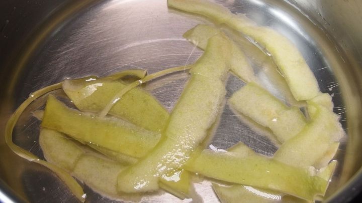 Im Kochtopf sind verschiedene gr&uuml;ne Schalenst&uuml;cke in Wasser, um Flecken aus Kocht&ouml;pfen zu entfernen.