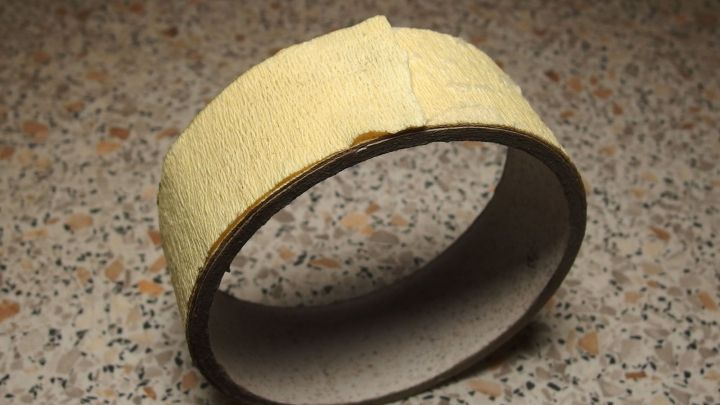 Malerkreppband liegt auf einer rauen Oberfl&auml;che und wartet darauf, f&uuml;r Malerarbeiten oder Bastelprojekte genutzt zu werden.