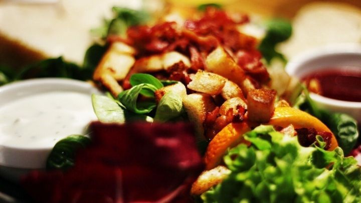 Ein frischer Salat mit buntem Gem&uuml;se und Saucen wird auf einem Tisch pr&auml;sentiert, ideal f&uuml;r Ess-Tipps im Nachtdienst.