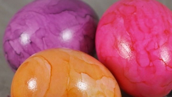 Bunte Ostereier liegen nah beieinander und gl&auml;nzen im Licht, bereit f&uuml;r kreative Verwertung nach Ostern.