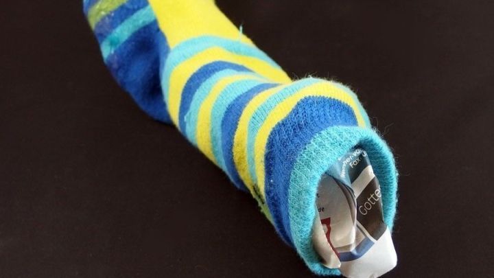 Bunte Socken dienen als Schuhspanner, indem sie in einen Schuh gesteckt werden, um dessen Form zu erhalten.
