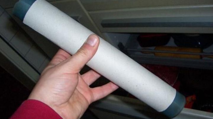 Ein Hand h&auml;lt eine Silikon-Backfolie, die sicher in einer K&uuml;chenschublade verstaut wird, um Platz zu sparen.