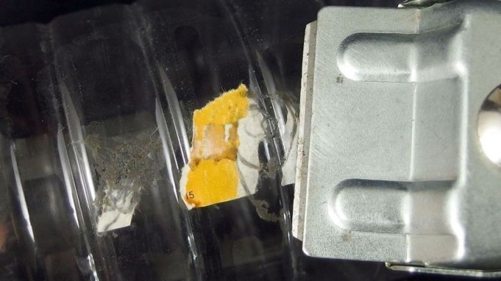 Ein Glas mit Kleberesten wird mit einem Werkzeug bearbeitet, um die Marmeladengl&auml;ser zu reinigen und aufzulockern.