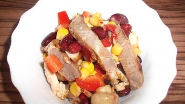 Ein Salat mit Grillfleischresten zeigt bunte Gem&uuml;se- und Bohnenst&uuml;cke in einer wei&szlig;en Sch&uuml;ssel, kreativ angerichtet.