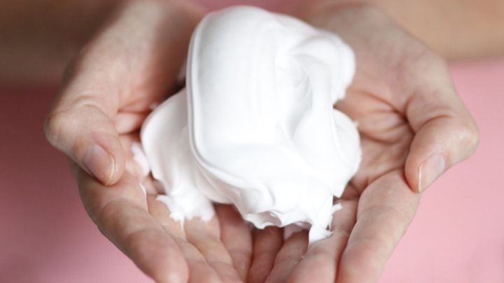 Wei&szlig;e Rasierschaum wird in H&auml;nden gehalten, um gegen Karottenflecken vorzubeugen oder diese zu entfernen.