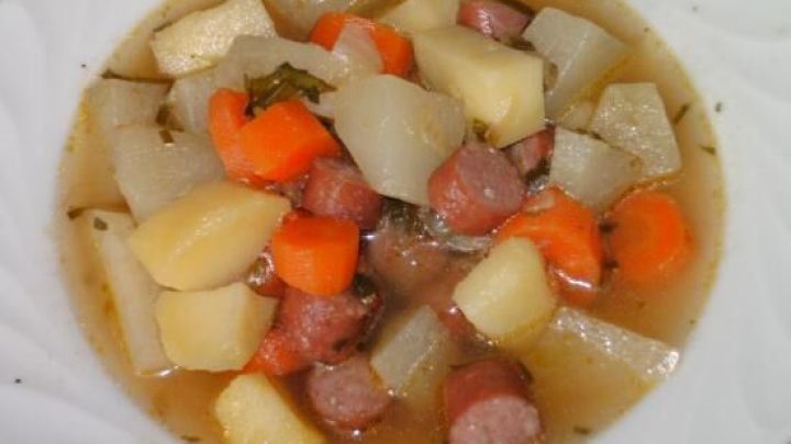 Ein leckerer Kohlrabi-M&ouml;hren-Eintopf in einer wei&szlig;en Sch&uuml;ssel, voller bunter Gem&uuml;sew&uuml;rfel und Br&uuml;he.