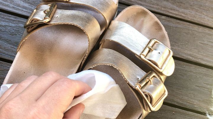 Ein Benutzer reinigt die Innenseite von Schuhen mit einem Reinigungstuch auf einem Holzuntergrund.