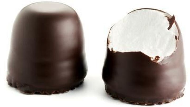 Zwei Mohrenk&ouml;pfe stehen nebeneinander vor einem wei&szlig;en Hintergrund; einer ist angebissen, zeigt fluffige F&uuml;llung.