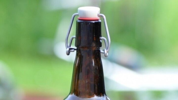 Ein braunes "Ritterbier" steht auf einem Tisch. Umgeben von gr&uuml;ner Natur bietet es eine passende Atmosph&auml;re f&uuml;r eine Party.