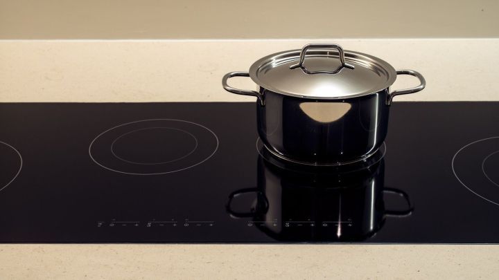 Ein Topf steht auf einem Induktionskochfeld und erhitzt sich in einer modernen K&uuml;chenumgebung.