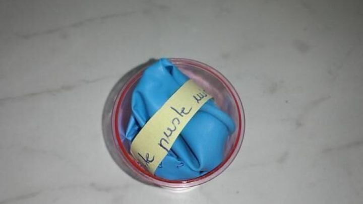 Eine bunte, runde Kiste enth&auml;lt eine blaue Serviette mit einer Einladung, ideal f&uuml;r originelle Kindergeburtstagseinladungen.