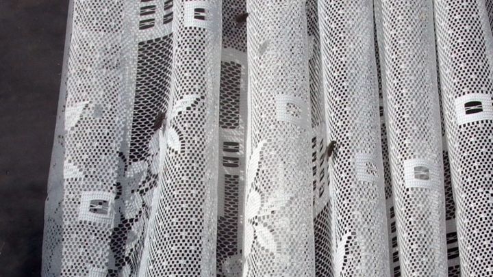 Vor einem Fenster h&auml;ngen durchsichtige Vorh&auml;nge, die Fliegen davon abhalten, ins Zimmer zu gelangen.