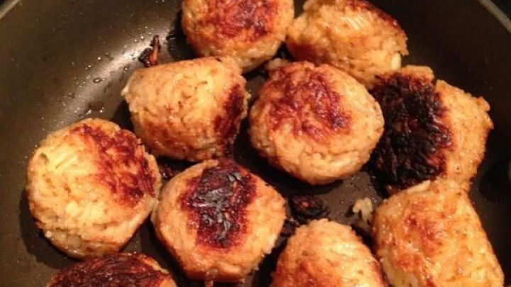 Praktische Resteverwertung: Gebackene Reisk&uuml;chlein liegen knusprig in einer Pfanne, gleichm&auml;&szlig;ig goldbraun angebraten, zum Servieren bereit.