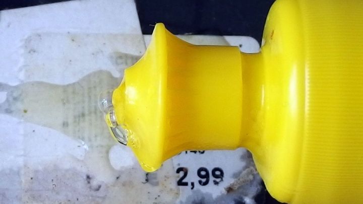 Ein gelber Kleber wird auf eine Preis ETIKETTE aufgetragen, um diese sauber und materialfreundlich zu entfernen.