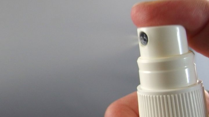 Ein Hand-Trigger-Spr&uuml;hflasche wird gedr&uuml;ckt, um einen Raumspray aus dem Garten freizusetzen, der in einer K&uuml;che verwendet wird.