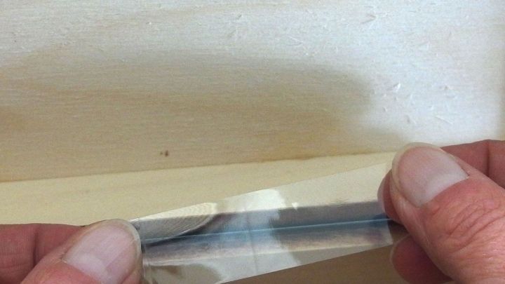 Klebeband hilft, Staub und Schmutz aus Rillen und Ecken zu entfernen, w&auml;hrend die H&auml;nde das Band abziehen.