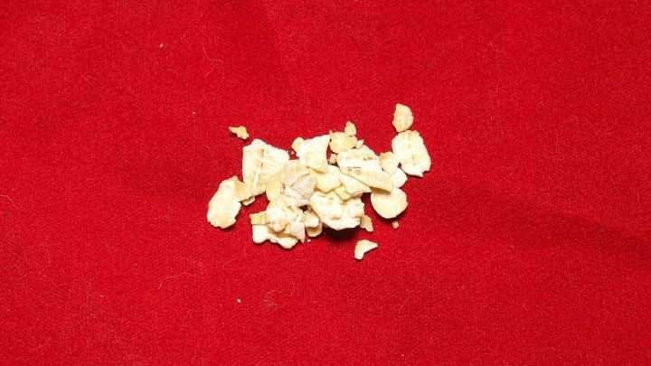 Ein Haufen aufgepopptes Popcorn liegt verstreut auf einem roten Tuch, w&auml;hrend kleine Kinder im Hintergrund spielen.