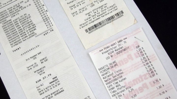Mehrere Quittungen liegen auf einem schwarzen Hintergrund, um Sparpotentiale in den Finanzen sichtbar zu machen.