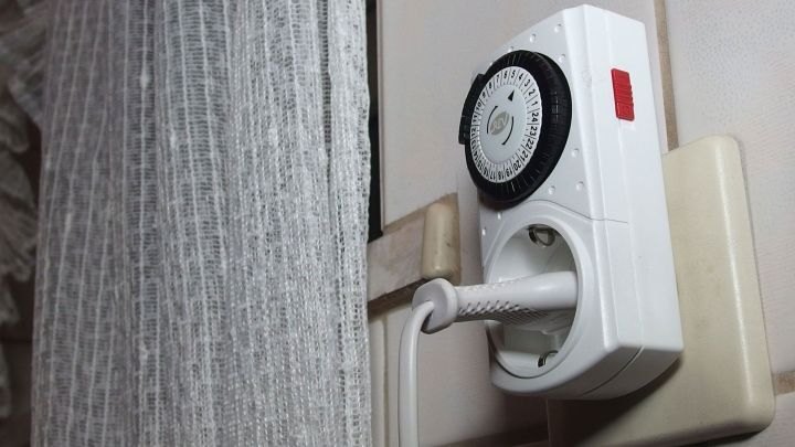 Eine Zeitschaltuhr ist an einer Wandmontage installiert und steuert Ger&auml;te im Kontext eines Wohnraums.