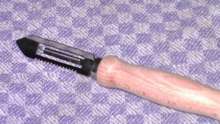 Ein Kartoffelsch&auml;ler liegt auf einem gestreiften Tuch und ist bereit, &Auml;pfel auszustichen.