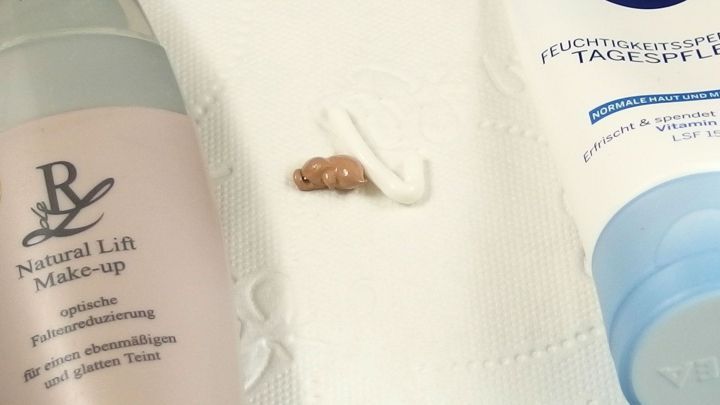 Eine Foundation und eine Tagescreme liegen auf einem wei&szlig;en Tuch, beide werden gemischt, um das Make-up aufzuhellen.