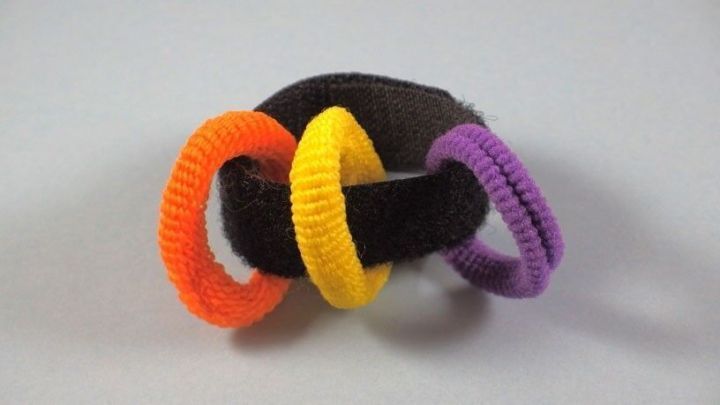 Farbenfrohe Haargummis sind auf einem Kabelbinder aufgereiht, um ein einfaches Aufbewahrungssystem zu zeigen.