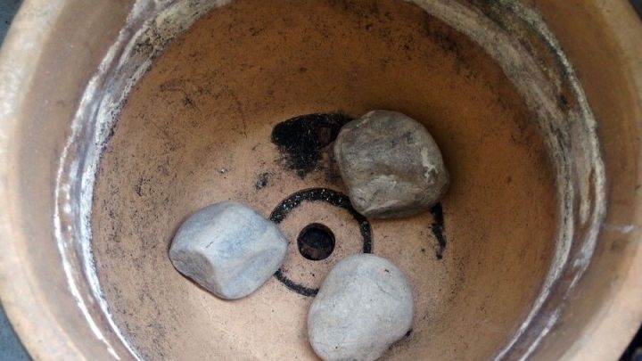 Faustgro&szlig;e Steine liegen in einem gro&szlig;en Blumentopf, um diesen zu beschweren und Stabilit&auml;t zu gew&auml;hrleisten.