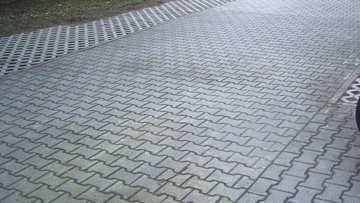 Auf einer gepflasterten Auffahrt sind deutliche &Ouml;lflecken sichtbar, die auf Reinigung mit Handwaschpaste warten.