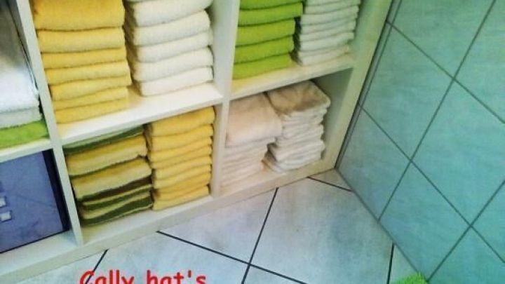 Bunte Handt&uuml;cher sind ordentlich im Regal gestapelt, w&auml;hrend ein Hinweis darauf hinweist: "Cally hat's gemacht!"