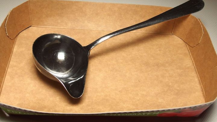 Ein Kochl&ouml;ffel liegt in einer praktischen Ablage aus einem Pappteller, um beim Kochen den Arbeitsplatz sauber zu halten.